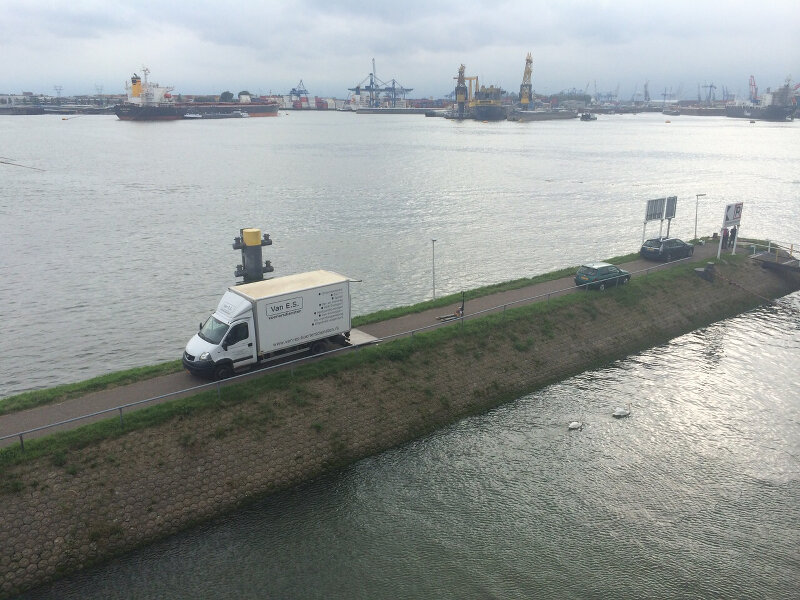 Een Van E.S. koeriersbus onderweg langs de Rotterdamse haven